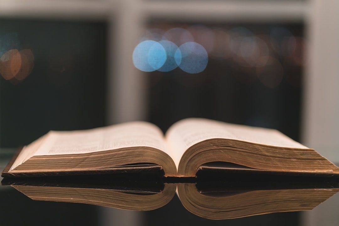 Aufgeschlagenes altes Buch mit Spiegelung und unscharfen Lichtern